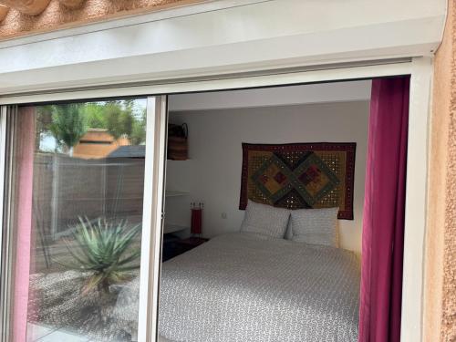 une chambre avec un lit et une porte coulissante en verre dans l'établissement St Cyprien Aygual Maison avec bel exterieur, à Saint-Cyprien