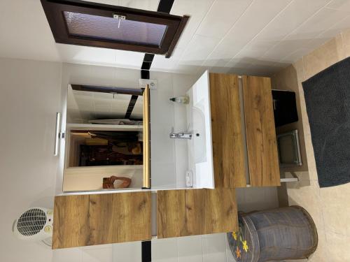 une petite cuisine avec des armoires en bois dans une caravane dans l'établissement St Cyprien Aygual Maison avec bel exterieur, à Saint-Cyprien