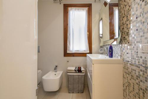 a bathroom with a sink and a toilet and a mirror at Manessy in Badesi