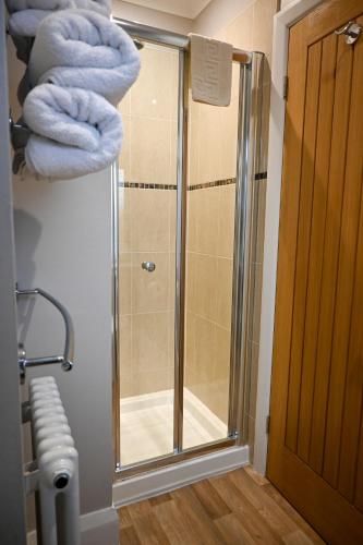 a shower with a glass door and a towel at Seaside Hideaway in Scarborough