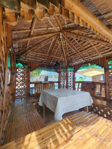 a dining room with a table in a hut at JFive Homes by the Sea in Lianga