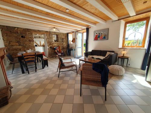 un salon avec une table et des chaises dans l'établissement Jolie maison en pierre avec grand jardin pour 6, à Guissény