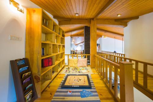 a room with wooden shelves and a rug on a floor at Alaya Stays Country Ville - 3 BHK Pet Friendly Villa with Lush Garden & Kids Room in Kokliyal Gaon