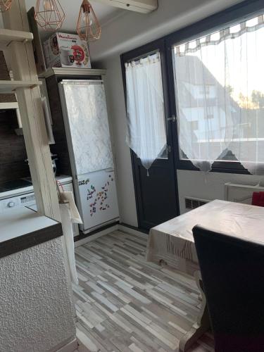 Cette chambre dispose d'une cuisine avec une porte et une table. dans l'établissement Appartement en attique 2 balcons 50m2 au calme, à Hoenheim