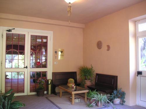 a living room filled with furniture and plants at Hotel Cavalieri in Passignano sul Trasimeno