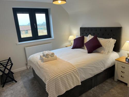 a bedroom with a bed with a teddy bear on it at Pineapple Cottage in Thorndon