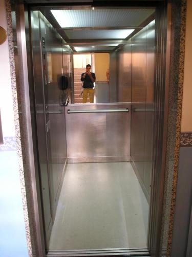 a man taking a picture of a mirror in a elevator at Hotel Cavalieri in Passignano sul Trasimeno