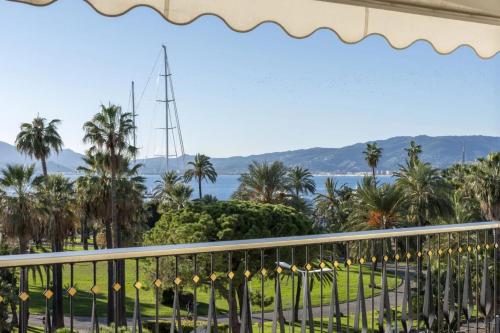 d'un balcon avec vue sur l'océan et les palmiers. dans l'établissement REF 2012 - Cannes Croisette - Apartment to rent sea view, à Cannes
