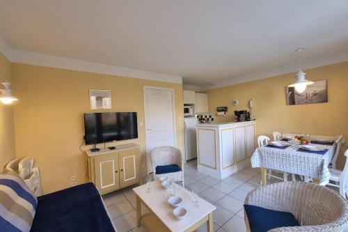 Il comprend un salon doté d'un canapé et d'une table avec une télévision. dans l'établissement Beautiful house with pool in Talmont-Saint-Hilaire, à Saint-Hilaire-de-Talmont