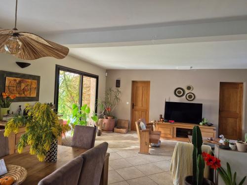 un salon avec une table et une télévision dans l'établissement Villa 170m2 avec piscine près d Aix en provence 7 couchages, à Éguilles