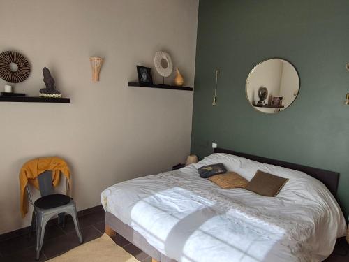 une chambre avec un lit avec un miroir et une chaise dans l'établissement Villa 170m2 avec piscine près d Aix en provence 7 couchages, à Éguilles