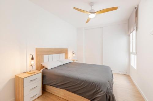 Un dormitorio con una cama y un ventilador de techo. en Alojamiento Entero En Aguilas, en Águilas