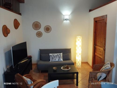 un salon avec un canapé et une télévision dans l'établissement Le Clos des évidences, à Domazan