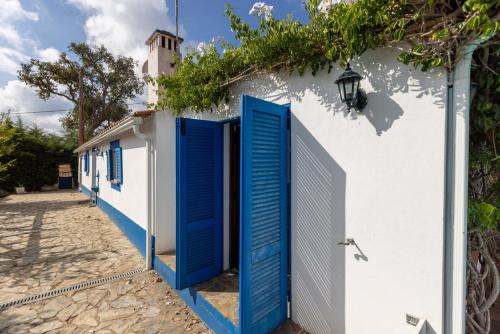a white building with blue doors on it at Monte dos Casarões- Casinha in Odemira