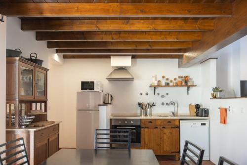 a kitchen with a table and a refrigerator at Casa Amarela Sao Luis in Odemira
