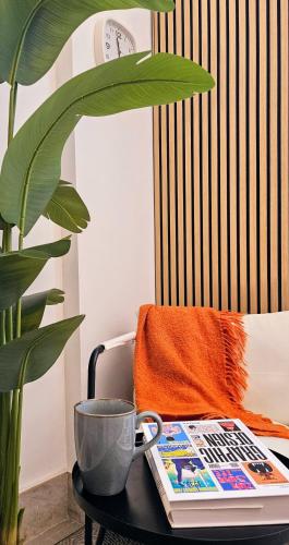 a coffee table with a book and a cup and a plant at Suite n 5 in Pompei