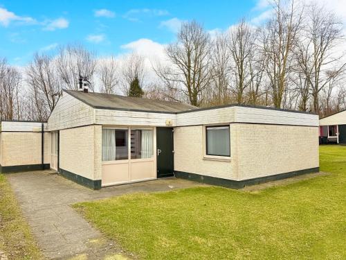 a brick house with a garage in a yard at Bungalowpark Simpelveld - Schakel 6 in Simpelveld