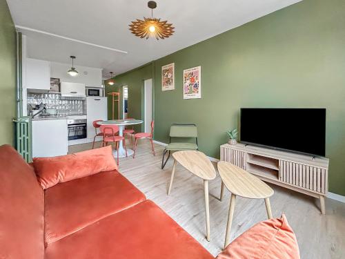un salon avec un canapé et une télévision à écran plat dans l'établissement Cosy T3 Plein Centre, Clim & Balcon, à Toulouse