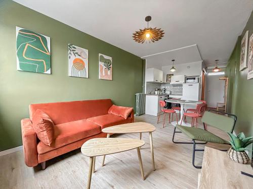 a living room with a couch and a kitchen at Cosy T3 Plein Centre, Clim & Balcon in Toulouse