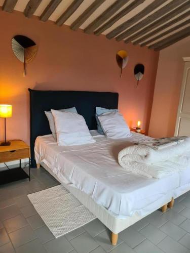 une chambre avec un grand lit avec des draps et des oreillers blancs dans l'établissement Chez marcel les arcs, aux Arcs-sur-Argens