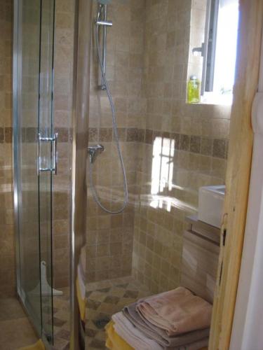 une douche avec une porte vitrée dans une salle de bain dans l'établissement Chez marcel les arcs, aux Arcs-sur-Argens