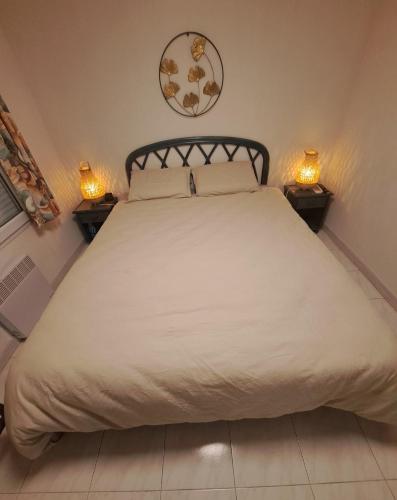 - une chambre avec un grand lit et 2 lampes dans l'établissement 2 pièces terrasse 39m2 à 500m de la plage, au Lavandou