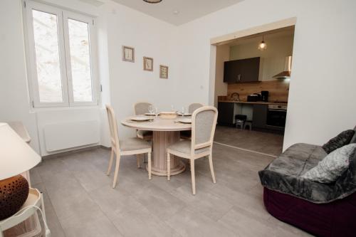 un salon avec une table, des chaises et un canapé dans l'établissement La Petite Pontissalienne - Appartement Centre de Pontarlier, à Pontarlier