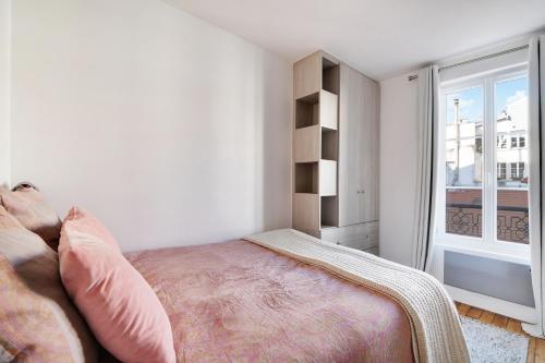 une chambre blanche avec un lit et une fenêtre dans l'établissement Jardin de Luxembourg - Arène de Lutece, à Paris