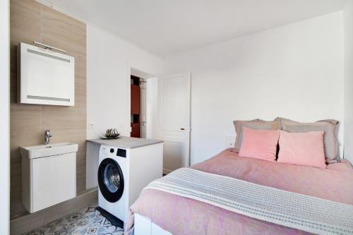 - une chambre avec un lit et un lave-linge dans l'établissement Jardin de Luxembourg - Arène de Lutece, à Paris