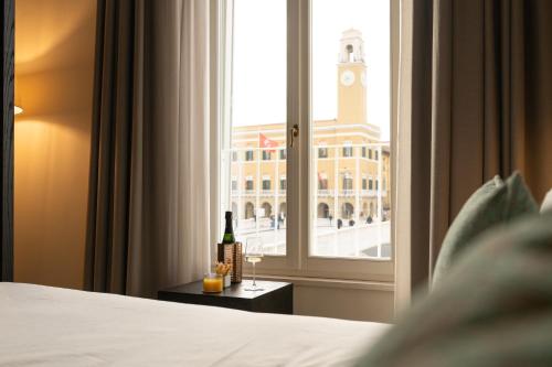 a bedroom with a bed and a window with a bottle of wine at Anna Teresa Luxury in Pisa