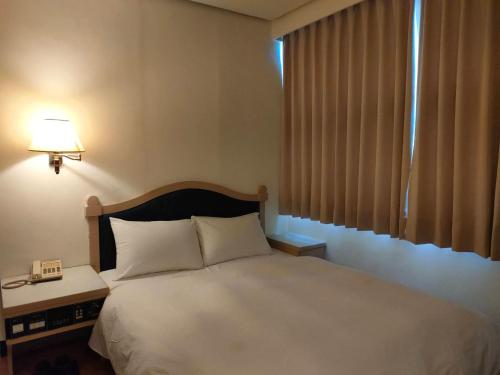Un ou plusieurs lits dans un hébergement de l'établissement DC Hotel