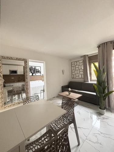 un salon avec une table, des chaises et un canapé dans l'établissement Residence Graziella Appartement 109, à Juan-les-Pins