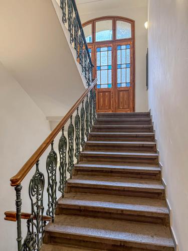 a set of stairs with a wooden door at Radost Residence The Heart of Unique Living in Prague