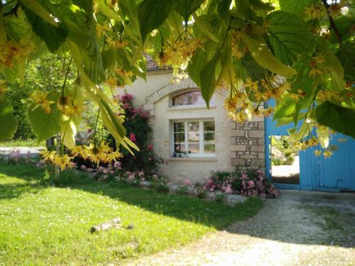une maison avec une porte bleue et des fleurs dans l'établissement La Maison d'hôtes de La Riviere, à Sceaux-du-Gâtinais
