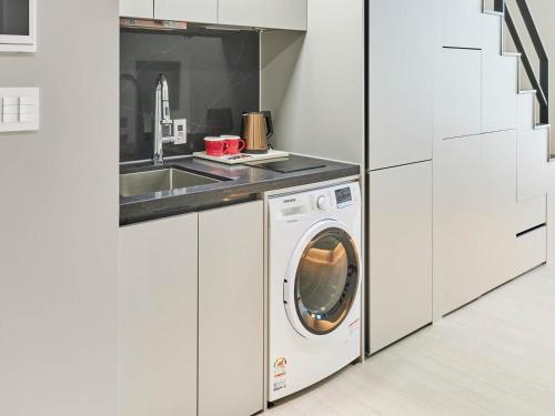 a kitchen with a washing machine and a sink at NewCZ Centum Hotel in Busan
