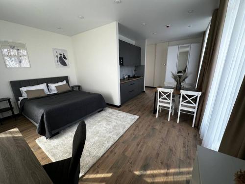 a bedroom with a bed and a table and chairs at Smart House Apartments in Lviv