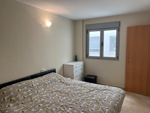 een slaapkamer met een bed en een raam bij Dúplex apartment en Peñíscola in Peñíscola