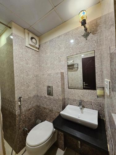 a bathroom with a toilet and a sink at Hotel Riddhi Inn in Udaipur