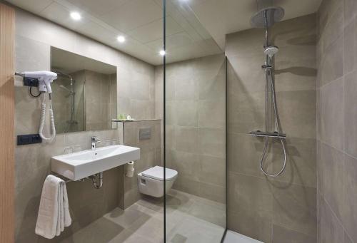 a bathroom with a shower and a toilet and a sink at NH Andorra la Vella in Andorra la Vella