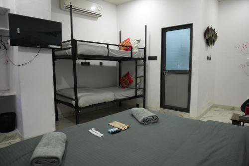 a bedroom with two bunk beds and a flat screen tv at Funky Backpackers in Udaipur