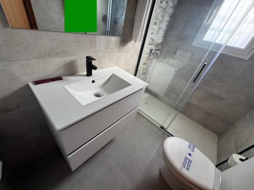 a white bathroom with a sink and a toilet at Hostal Miramar in Los Caños de Meca