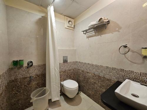 a bathroom with a toilet and a shower and a sink at Hotel Riddhi Inn in Udaipur
