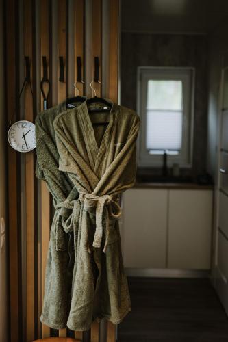 a towel hanging on a wall with a clock at ForRest Glamp Saulkrasti in Saulkrasti