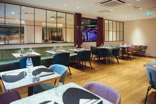 une salle à manger avec tables, chaises et fenêtres dans l'établissement Le Clos Rebillotte, à Luxeuil-les-Bains