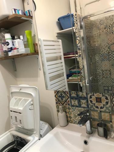 une salle de bain avec un lavabo, des toilettes et un miroir dans l'établissement Charming flat in Belleville, à Paris