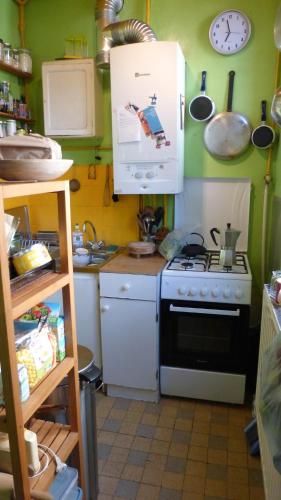 une cuisine avec une cuisinière et un micro-ondes dans l'établissement Charming flat in Belleville, à Paris
