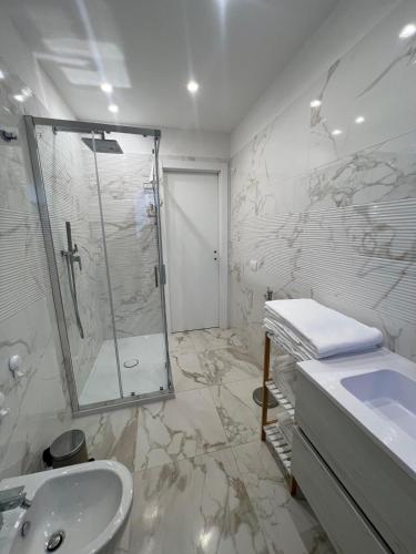 a white bathroom with a shower and a sink at La Casa di Mimi in Monopoli