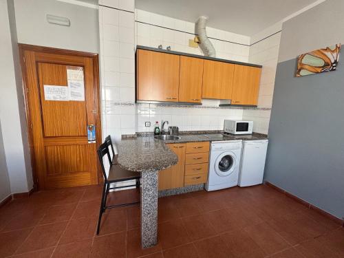 a kitchen with a table and a washing machine at Hostal Miramar in Los Caños de Meca