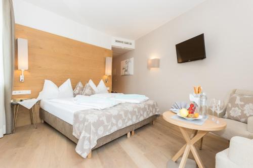 a hotel room with a large bed and a table at Das Alte Rathaus in Egna