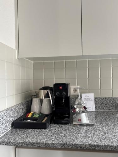 a kitchen counter with a coffee maker on it at Hôtel de l'Ecluse in Neuchâtel